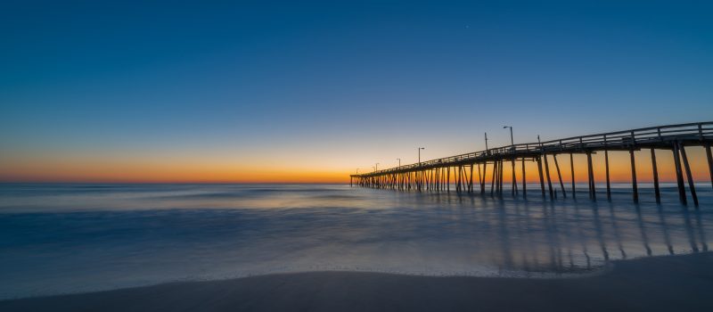 Beautiful sunset scene of the beach and pier in the Outer Banks of North Carolina.