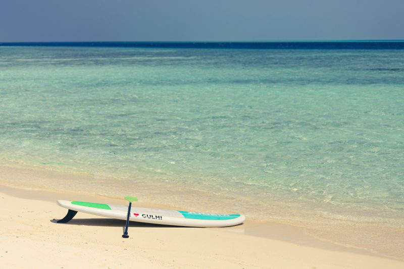 Paddle Board on beautiful white sand beach with clear water.