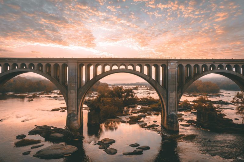 Scenic photo of the James River under the bridge in Richmond, Virginia during sunset.