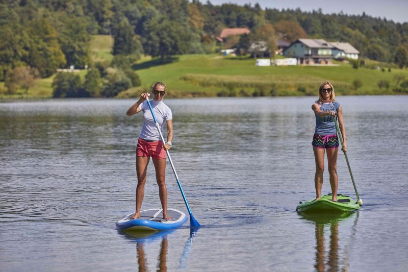 Women Holding Paddles on Paddle Board.