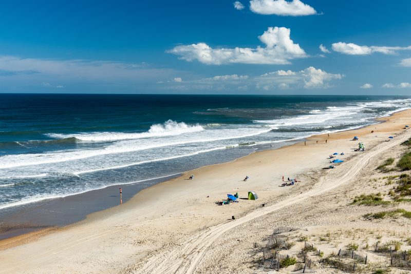 Zoomed out photo of the beach and waves at the Outer Banks in North Carolina.